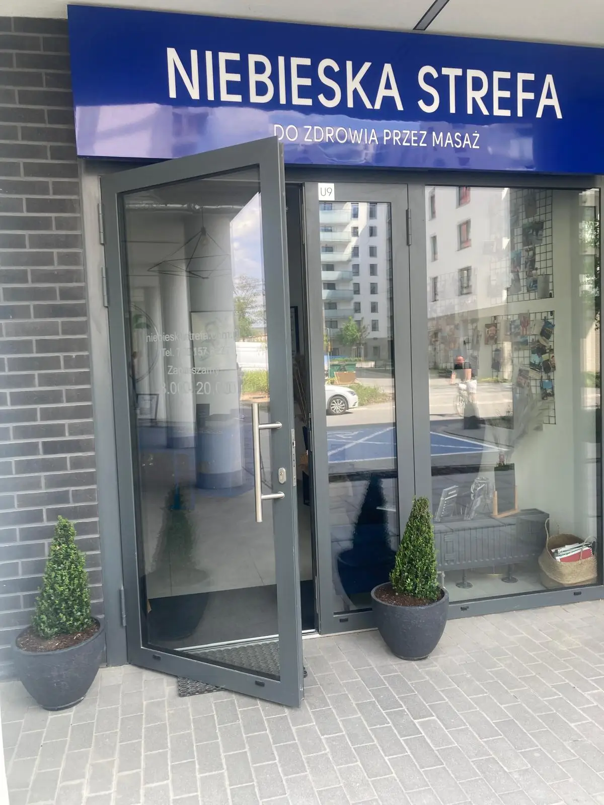 Niebieska Strefa widok na baner i drzwi wejściowe
